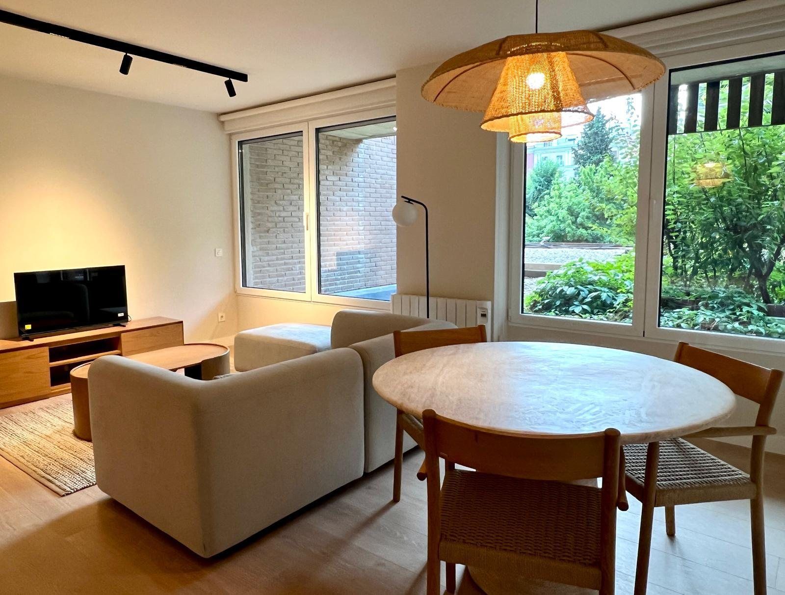 Comedor junto a las ventanas con vegetación exterior